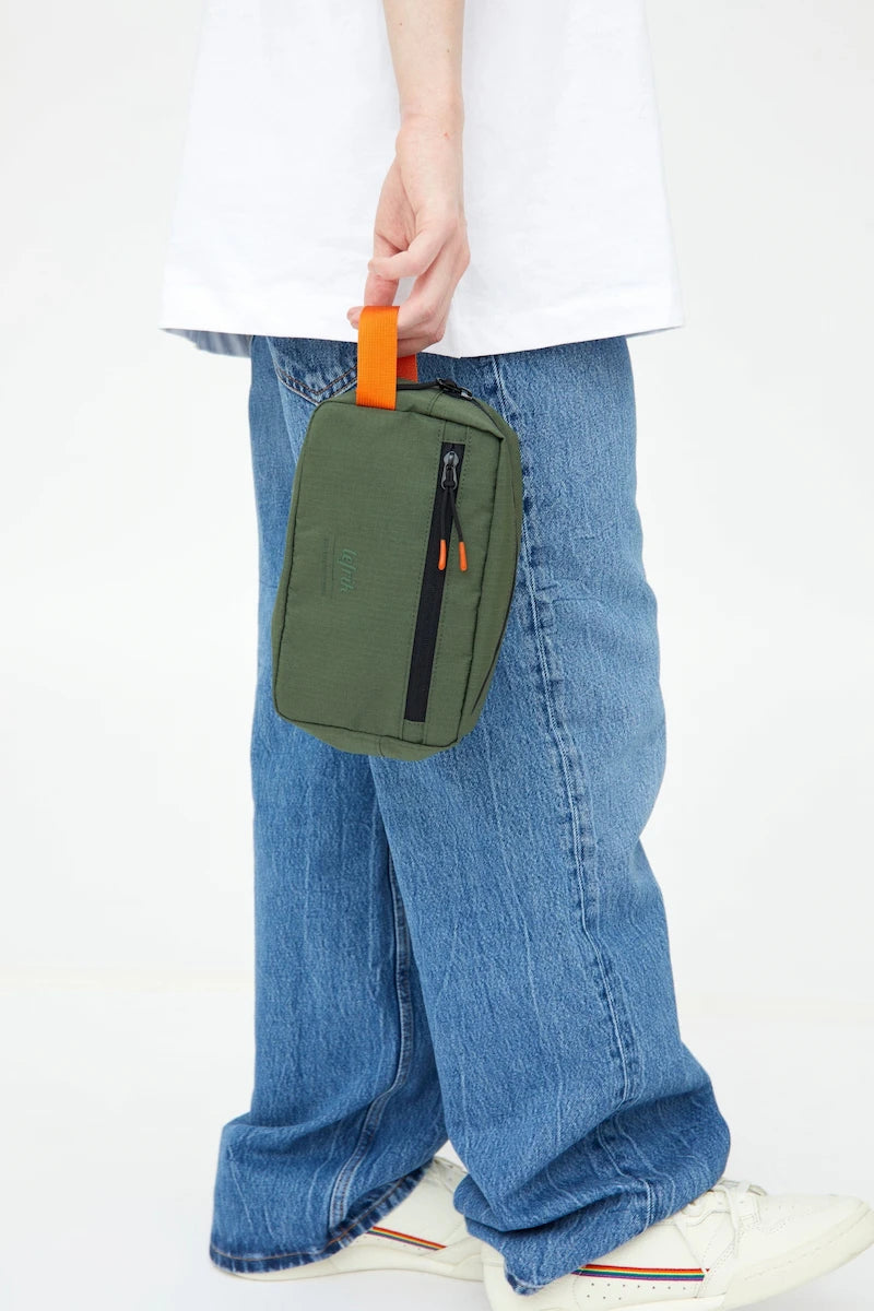 Dreng holder grøn lefrik toilettaske i orange strop