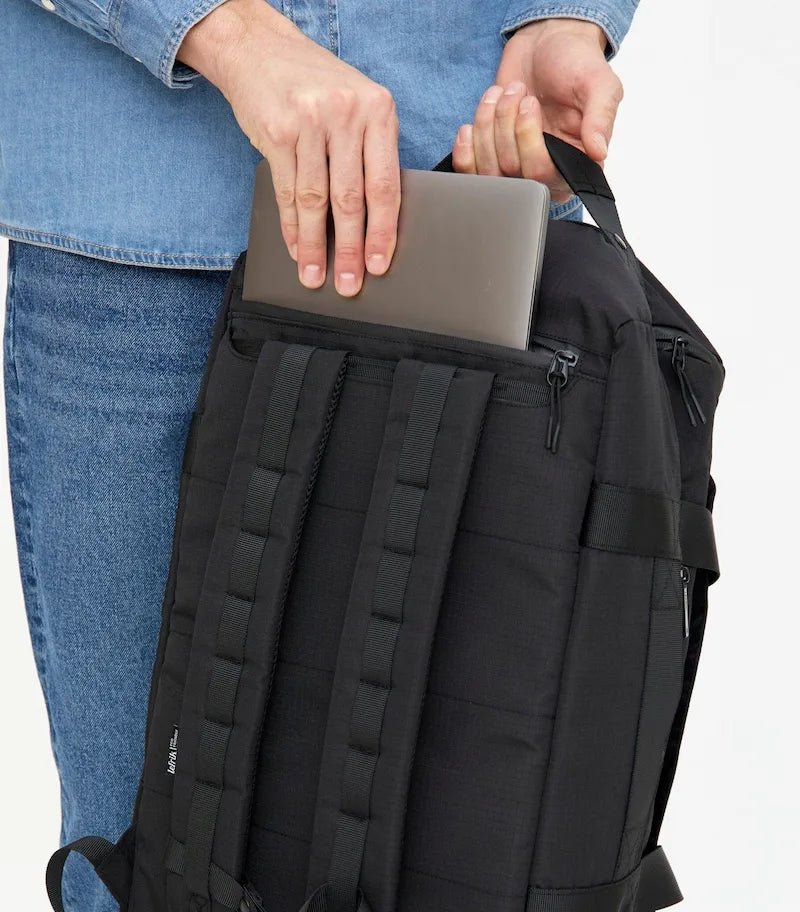 Dreng med computer i lommen på sort lefrik wanderer rygsæk