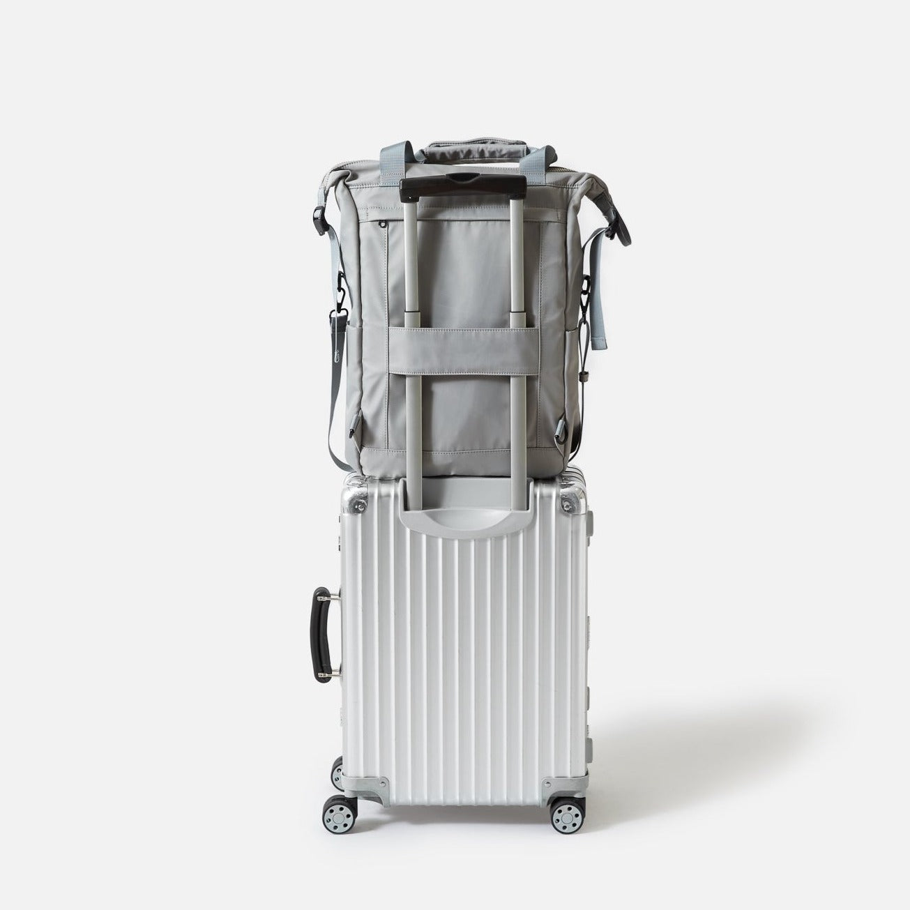 grå rygsæk på sølvfarvet kuffert