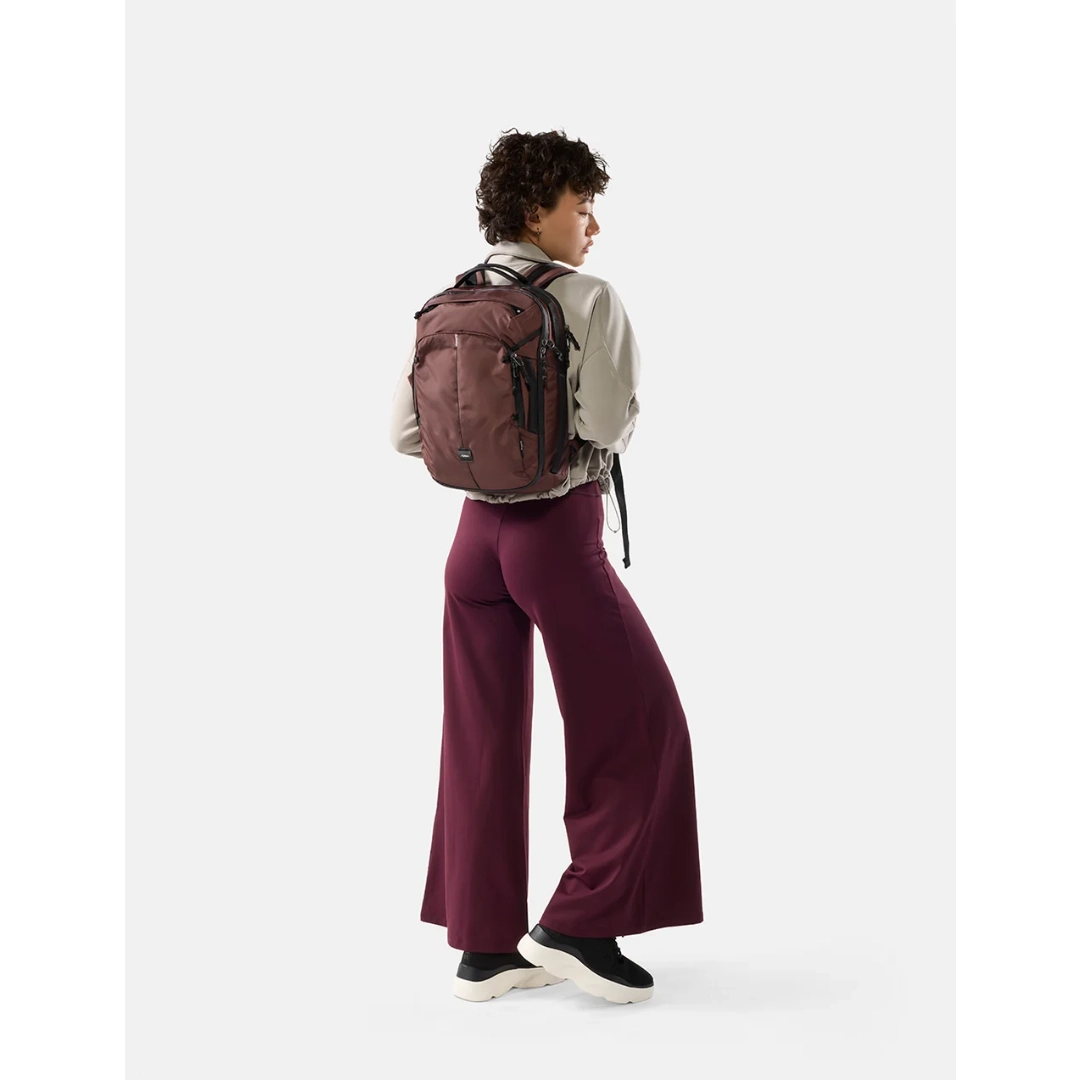 Kvinde med Matador 18 liter personal item travel pack , garnet/rødbrun