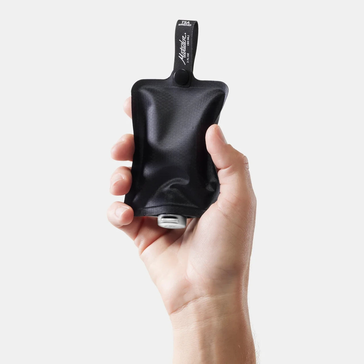 Matador flatpak toiletry bottle i hånden