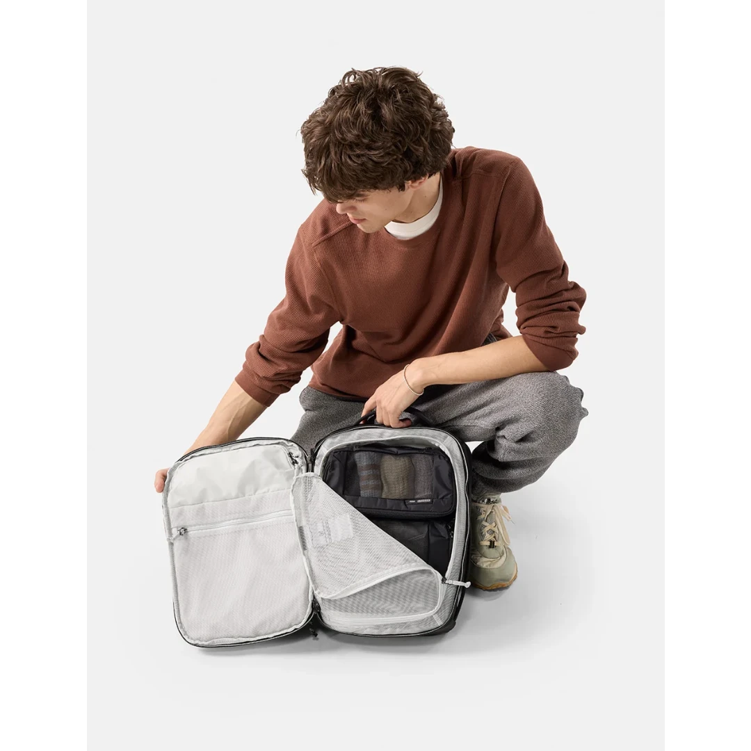 Mand med Matador 18 liter Personal Item Travelpack, sort, åben