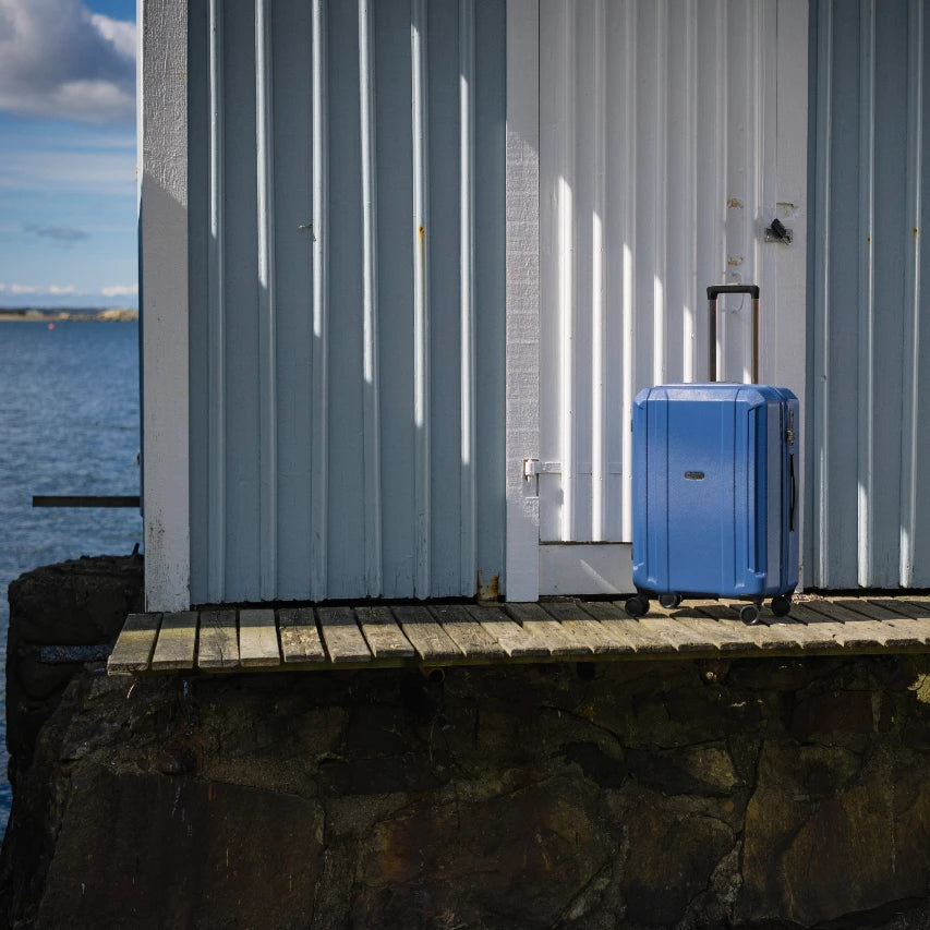 Epic kuffert, airwave neo, blå, stående på en bro ved havet