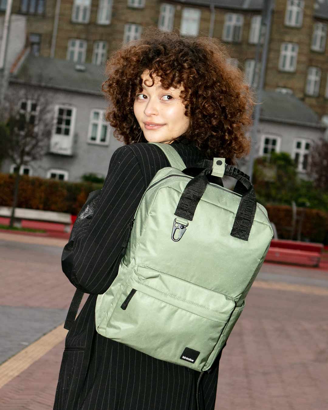 Kvinde bærer olivengrøn rygsæk
