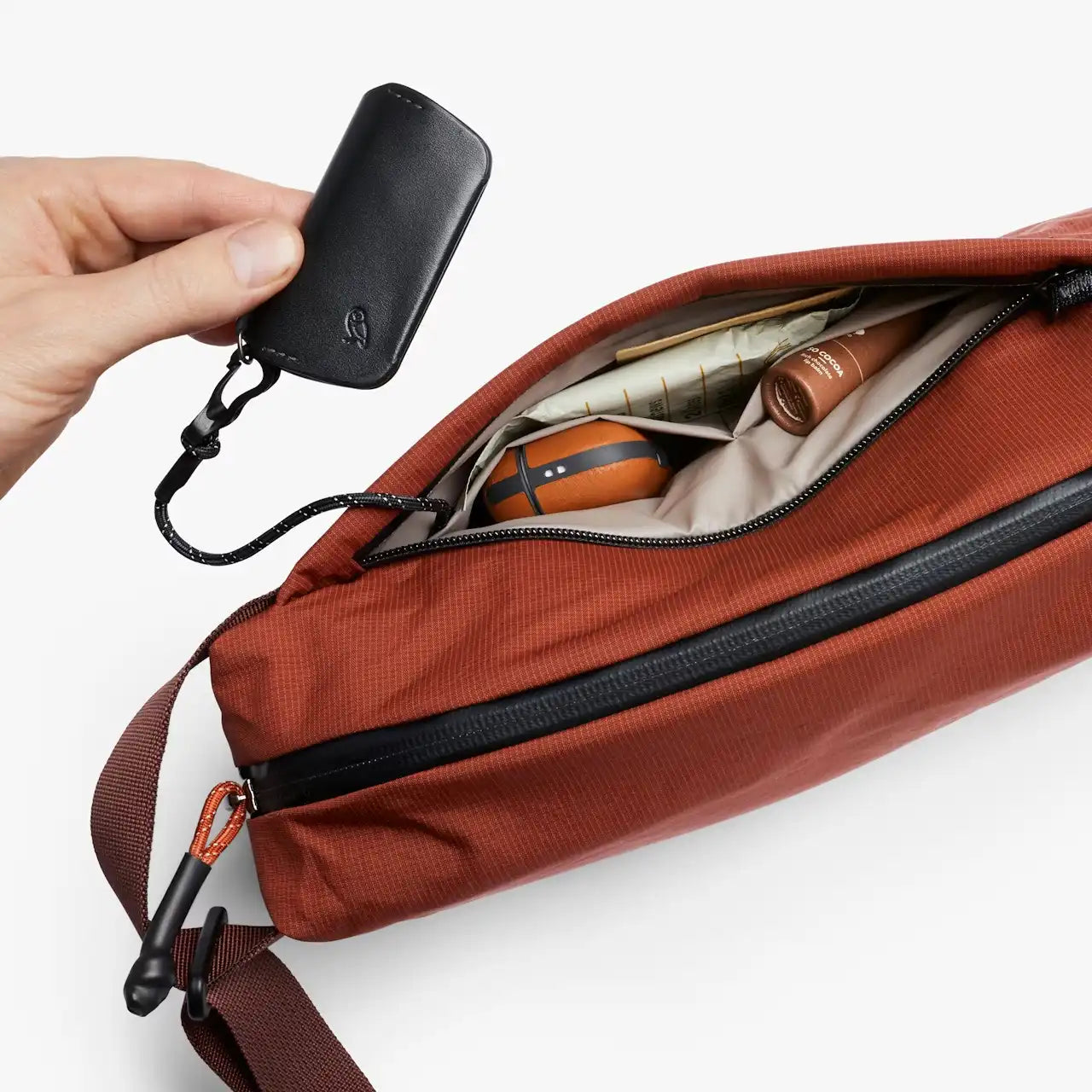 Bellroy lite sling clay, med åben frontlomme med indhold