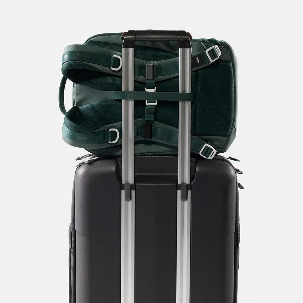Matador 18L personal item rygsæk, grøn, på kuffert