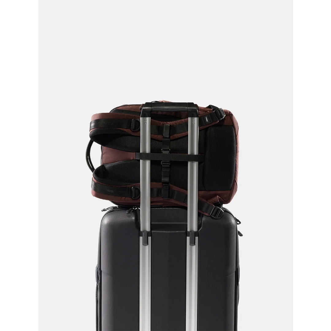 Matador 18 liter personal item travel pack , garnet/rødbrun, på kuffert