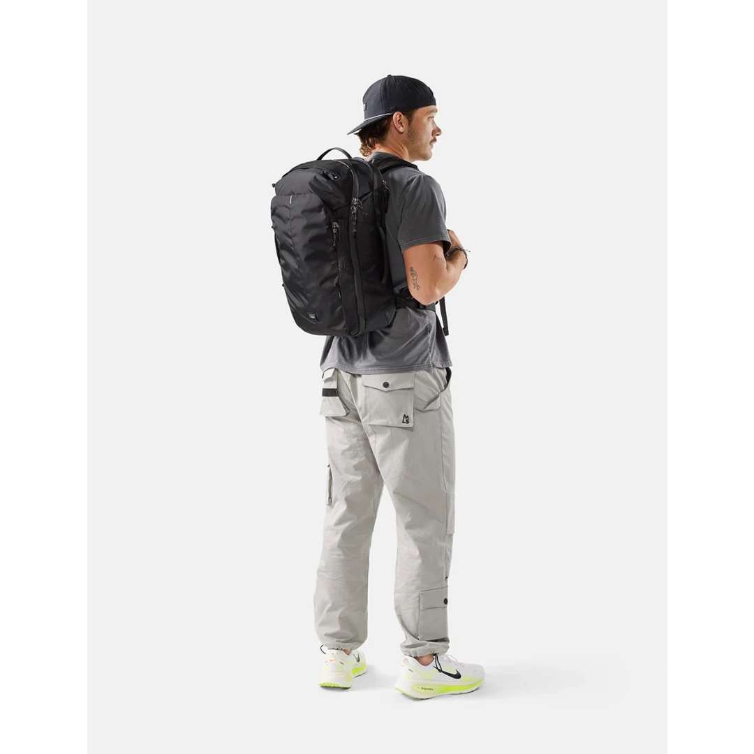 Mand med Matador 30 liter carry-on travel pack sort,
